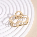 Detail view of a matte beige wave-shaped hair claw clip on a textured white display tray - Cloud Khaki