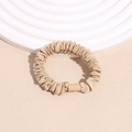 Detailed shot of pleated champagne satin scrunchie with soft silk texture and glossy finish - Khaki