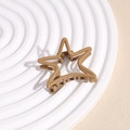 Close-up of matte khaki star-shaped hair claw clip with a strong metal spring on a tray - Light Coffee Star