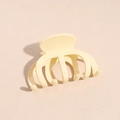 Dettaglio di un fermaglio per capelli a polipo beige crema con finitura lucida su fondo - Beige
