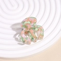Makro-Detail der Haarklammer aus Acetat mit Marmor-Textur und bunten Pastelltönen - Grün Rosa
