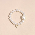 Detailed close-up of pearl hair tie with a golden heart charm and white beads - Heart Pearl Hair Tie Bracelet