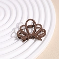 Detail of a matte brown crown-shaped hair claw clip on a white minimalist display stand - Crown Deep Coffee