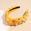 Dettaglio del cerchietto giallo annodato con perle finte e strass di cristallo lucidi - Giallo