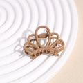 Macro detail of a matte coffee brown hair claw clip with its metal spring and teeth - Crown Coffee