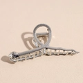 Dettaglio macro di un fermaglio per capelli a forma di serpente in metallo argentato - Serpente d'argento / Argento