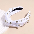 Detailed close-up of white knotted headband with pearls and sparkling gold-clawed crystals - White