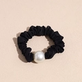 Dettaglio dell'elastico per capelli nero a pieghe con una grande perla bianca lucida - Stile Perla Nera