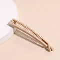 Dettaglio del fermaglio a banana color albicocca opaco con denti interni e chiusura - Beige