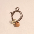 Close-up of brown elastic hair tie with faceted crystal pendant and resin cube charm - Khaki