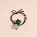 Dettaglio di elastico per capelli marrone con ciondolo in resina verde e sfera di strass - Verde