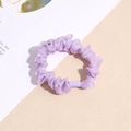 Detailed macro view of a purple organza scrunchie featuring a smooth plastic connector - Purple