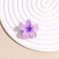 Detailed macro view of purple plumeria flower hair claw with gradient resin petals - Purple