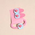 Detail van de roze en blauwe hart haarclips en scrunchie set op een displaykaart - Rozerood + Blauw