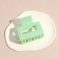 Modern mint green matte square hair claw clip placed on a white ceramic plate - Green