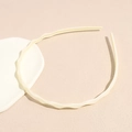 Dettaglio del cerchietto a onde color crema con denti antiscivolo per capelli bimba - Beige