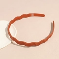 Detail view of wavy matte headband with non-slip inner teeth in warm caramel brown - Orange Red