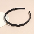 Detalle de diadema ondulada negra mate con dientes antideslizantes sobre bandeja - Negro