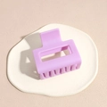 Macro view of light purple matte square hair claw clip on a decorative white plate - Purple