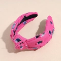 Detailaufnahme des pinkfarbenen Haarbandes mit Fransen und blau-weißem Karomuster - Rosa