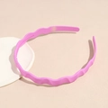 Detail of a bright pink wavy headband with matte finish and non-slip inner teeth - Magenta
