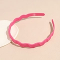 Close-up of bright pink wavy headband featuring non-slip inner teeth and matte texture - Rose Red
