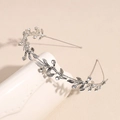 Detailed view of silver leaf vine headpiece with sparkling crystals on a ceramic stand - Silver