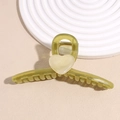 Detail of a large olive green heart hair claw clip with cream accents on a white display tray - Green