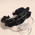 Detailed macro view of black velvet headband with white polka dots and grey rhinestones - Black