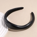 Close-up of elegant black padded faux leather headband with fine textured finish - Brown