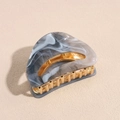 Macro shot of marble acetate French hair claw with golden metal teeth detail - Gray