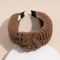 Detail of a brown knitted headband with a cross knot and thick textured weave design - Brown