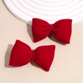 Dettaglio di due fermagli per capelli a fiocco in velluto rosso con trama ricca e lucentezza - Fiocco Imbottito Rosso