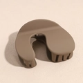 Dettaglio macro di un fermaglio per capelli marrone opaco con design aerodinamico a forma di U - Cammello