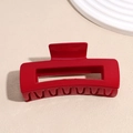 Dettaglio macro di un mollettone rettangolare rosso lucido con design traforato - Stile Quadrato Rosso (10.5cm)