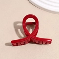 Dettaglio di una molletta per capelli rossa lucida con un elegante design a cerchi incrociati - Stile Nodo Rosso Piccolo (8cm)