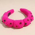 Close-up of pink plush headband featuring sparkling red and green rhinestone embellishments - Rose Red