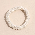 Dettaglio di un elastico per capelli con perle bianche e raffinata trama intrecciata - Bianco