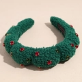 Detailed close-up of plush dark green headband with red and green rhinestones and label - Green