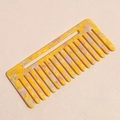 Detail view of wide-tooth marble texture hair comb in yellow and purple acetate finish - Yellow