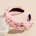 Detail of pink knotted headband with white pearls, rhinestones, and rugby metal charm - Light Pink