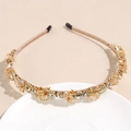 Close-up of champagne crystal headband with sparkling rhinestones on ceramic plate - Champagne