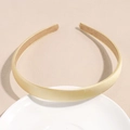 Dettaglio del cerchietto in raso color oro champagne su un vassoio di ceramica - Giallo
