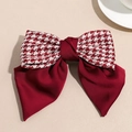 Detail der roten Satin-Schleifen-Haarklammer mit Hahnentrittmuster und mehrlagigem Design - Karo Roter Federclip