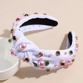 Detail view of white fabric headband featuring pink pearls and colorful rhinestone accents - White