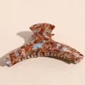 Détail d'une pince à cheveux en acétate marbré ambre avec inscription dorée - Marbre Bleu Rouge