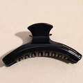 Detail of black glossy hair claw with golden handmade to France logo and curved design - Black