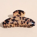 Nahaufnahme der Acetat-Haarklammer in Schildpatt-Optik mit goldenem Logo-Detail - Leopardenmuster