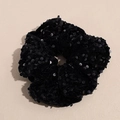 Vue détaillée d'un chouchou en velours noir orné de paillettes brillantes et de plis souples - Noir