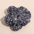 Vue détaillée du chouchou en velours gris avec des paillettes argentées brillantes et texture - Gris